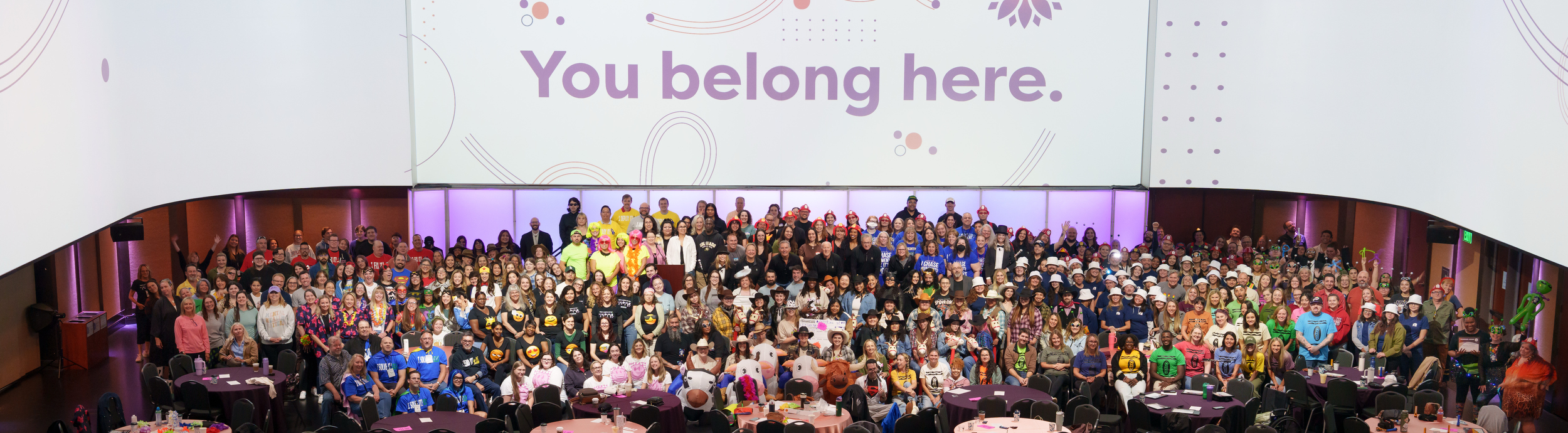 All Staff Celebration Photo of 450 staff with a large banner behind them that states "You Belong Here."